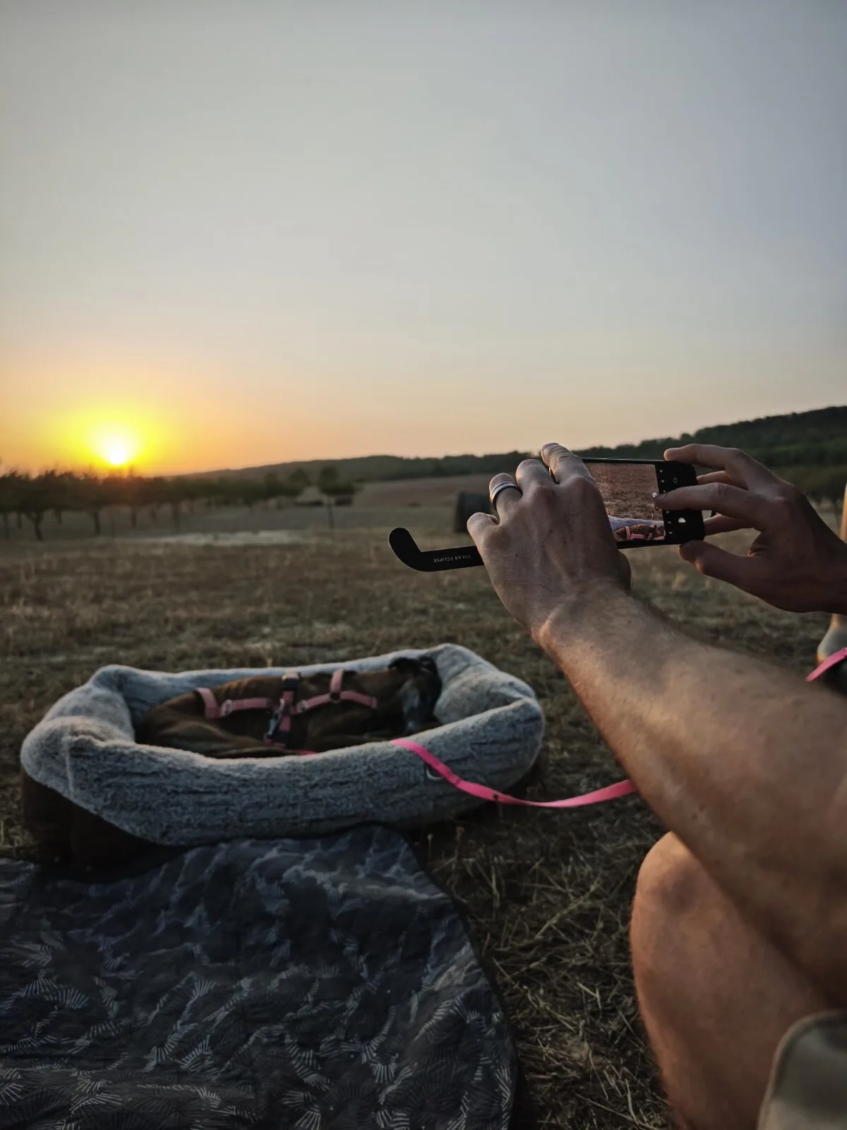 The phone with a taped glass taking a photo of the eclipse
